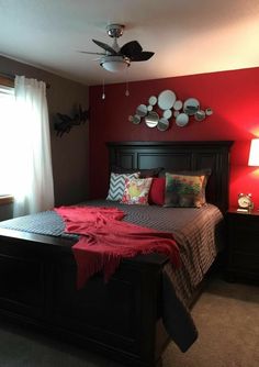 a bed room with a neatly made bed and red walls