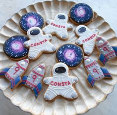 some cookies are on a plate with space related designs and words that spell out the word consta