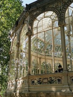 the inside of a glass and stone building with trees in the background