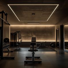 a dimly lit gym with exercise equipment in the foreground and on the far wall