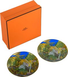 an orange box with two plates in front of it and another one on the ground