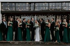 a group of people standing next to each other in front of a building with lights