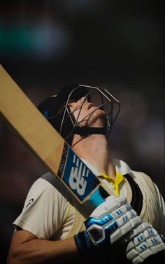 a man holding a cricket bat in his hands