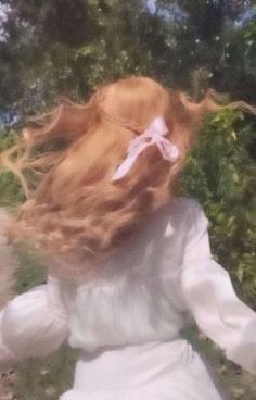 a woman with long red hair wearing a white dress