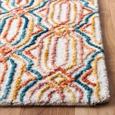 a multicolored area rug on a wooden floor with a wood floor in the background