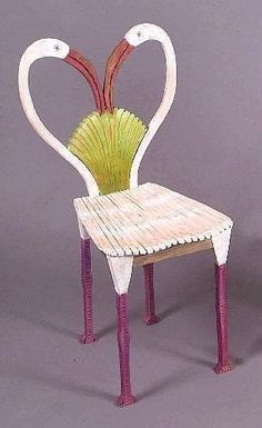 a white chair with pink legs and a green plant in the shape of a heart