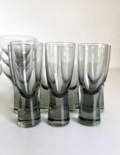 several glasses are lined up on a table top with one empty glass in the middle