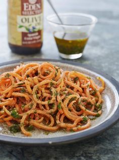 a plate full of food sitting on a table next to a bottle of olive oil