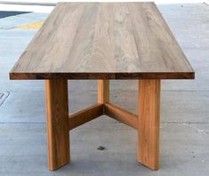 a wooden table sitting on top of a sidewalk