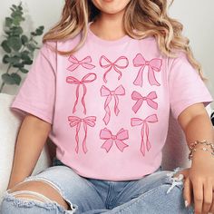 Introducing our Coquette Bow Graphic Tee – a charming addition to your casual wardrobe. This pink-colored, short-sleeve tee features a delicate bow graphic, adding a touch of elegance and femininity to your everyday style. *Will Ship in 3-5 Days* Size Suggestions: Small: 2-4 Medium: 6-8 Large: 10-12 XL: 14-16 2XL: 18-20 3XL: 22-24 Fabric Content: 52% Cotton 48% Polyester Care Instructions: Machine wash, cold. Tumble dry, low. Do not iron decoration. SKU: #242587 Trendy Summer T-shirt With Bow, Casual Summer T-shirt With Pink Bow, Casual Crew Neck T-shirt With Bow Print, Casual Short Sleeve T-shirt With Pink Bow, Feminine Cotton Short Sleeve T-shirt, Feminine Pink Crew Neck T-shirt, Cute Bow T-shirt For Spring, Summer Bow T-shirt With Short Sleeves, Summer T-shirt With Bow And Short Sleeves