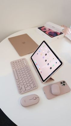 there is a tablet, keyboard and mouse on the table with other items around it