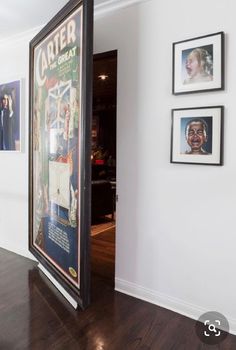 an open door leading into a room with pictures on the wall and wood flooring