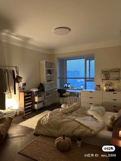 an unmade bed sitting in a bedroom next to a desk and window with lights on