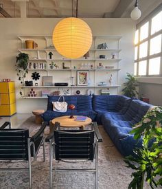 a living room filled with furniture and a large yellow light hanging over the top of it