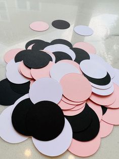 a table topped with lots of black and pink paper circles