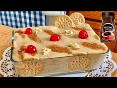 a cake with cookies and cherries on it sitting on top of a doily