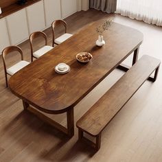 a wooden table with white chairs and plates on it in front of a large window