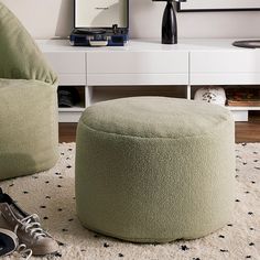 a pair of shoes sitting on top of a rug next to a footstool