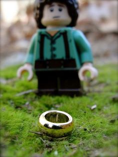 a lego figure with a ring in the grass