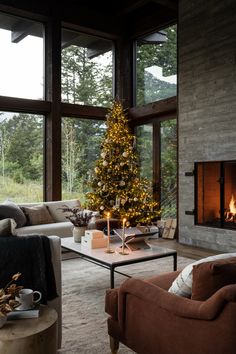 a living room filled with furniture and a christmas tree in front of a fire place