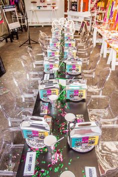 there are many plastic chairs and tables with confetti on them, all lined up