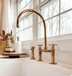 a kitchen sink with brass faucet and soap dispenser