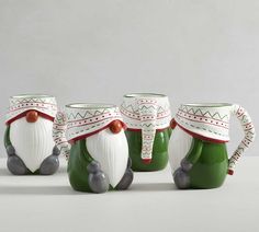 four green and white santa claus mugs sitting next to each other