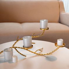 two candles are sitting on a table in front of a couch