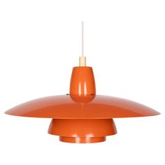 an orange pendant light hanging from a ceiling