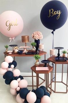 a table with balloons and other decorations on it, including a sign that says boy