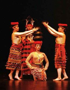 the dancers are dressed in colorful costumes and headdresses, with their hands on their hips