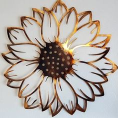 a metal sunflower is mounted to the wall