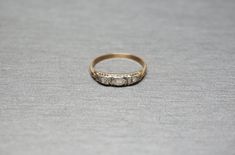 a three stone ring sitting on top of a gray surface with no one around it