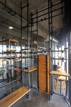 the inside of a building with metal pipes and wooden benches