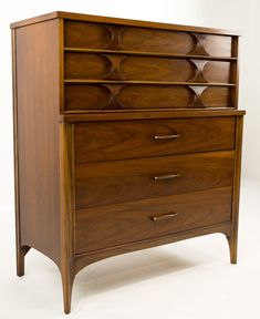 a wooden dresser sitting on top of a white floor