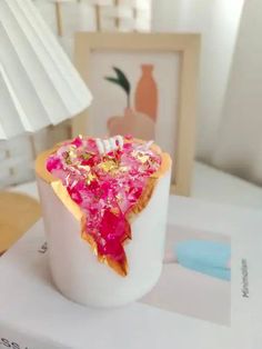 a white vase filled with pink and gold confetti on top of a table