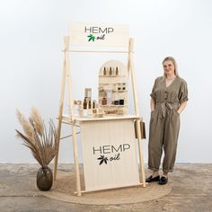 a woman standing in front of a hemp oil stand with her hand on the counter