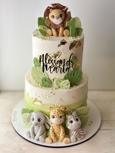 a three tiered cake decorated with animals and leaves