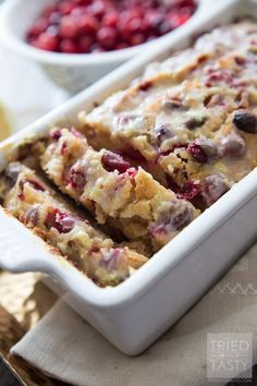 a close up of food in a pan with berries on the side and another bowl behind it