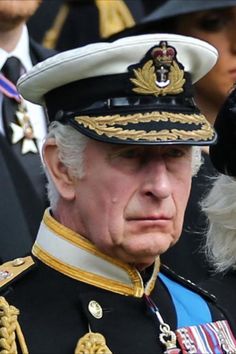 an older man in uniform with other people behind him and one dog on his shoulder