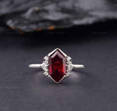 Dutch Marquise Red Ruby Lab Diamond Engagement Ring, Hexagon Cut Red Diamond Ring For Her, Dutch Marquise Cut Red Ruby Gemstone Ring Center Stone: Shape: Hexagon cut (Dutch Marquise) Type: Lab Created Ruby CTS: 2.50 CT Approx. Size: 12*7 mm Approx.  Color: Red Clarity: VVS Side Stone: CTS: 0.10ct Approx. Shape: Round And Princess Moissanite Color: DEF Clarity: VVS Also Available In Purple: www.etsy.com/listing/1585232812 Can Be Made In 10/14/18k Rose/Yellow/White Gold, Silver, Or Platinum. Why buy Moissanite over Diamond? ● Moissanite is pocket-friendly, it is almost 1/10 of the diamond price. ● Moissanite is Conflict-free and eco-friendly, whereas a diamond can be a conflicted diamond and it's non eco-friendly. ● There is no higher resale value of a diamond, in moissanite, you don't have Silver Ruby Engagement Ring, Red Diamond Engagement Ring, Ascher Cut, Red Diamond Ring, Red Engagement Ring, Lab Diamond Engagement Ring, Emerald Cut Rings, Red Diamond, Festival Jewelry