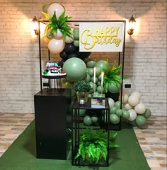 a birthday party with balloons and greenery