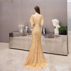 Elegant V-neck Backless Dress For Gala, Luxury Fitted V-neck Gown, Glamorous V-neck Evening Dress With Back Opening, Evening V-neck Backless Dress With Fitted Bodice, Elegant V-neck Backless Party Dress, Luxury Mermaid Dress For Evening Prom, Luxury Mermaid Dress With Sweep Train For Evening, Gold V-neck Evening Dress With Sweep Train, Elegant Embellished V-neck Evening Dress