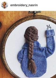 a woman's hair is braided into a pony tail in a blue sweater