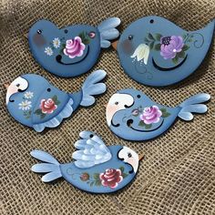 four blue birds with flowers painted on them