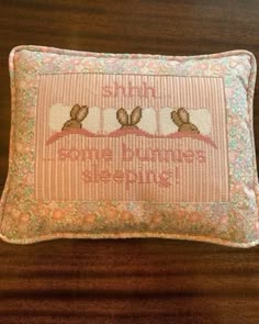 a cross stitched pillow with three birds on it, and the words shine in pink