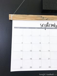 a calendar hanging on a wall with the word september written in black and white ink