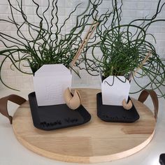 two planters sitting on top of a wooden tray next to each other with paper in them