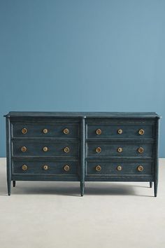 two black dressers side by side with gold knobs on the doors and drawers