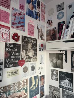 a wall covered in pictures and magnets next to a white shelf filled with books